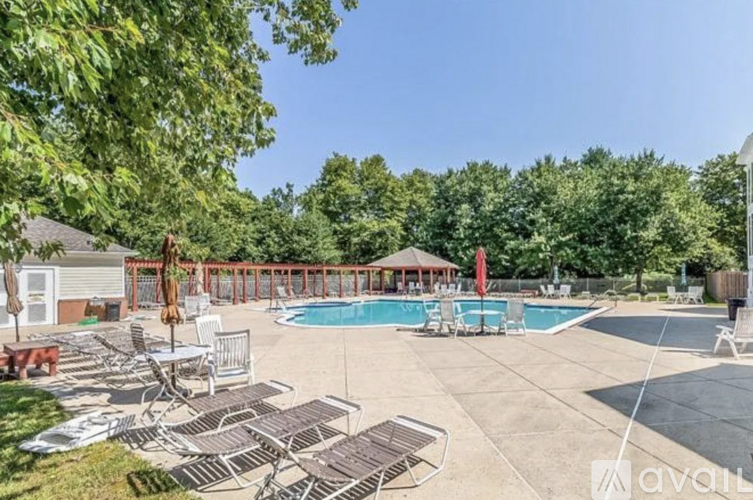 A large outdoor pool area with lounge chairs and a gazebo.