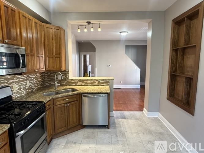 A kitchen with wooden cabinets and a stainless steel dishwasher.