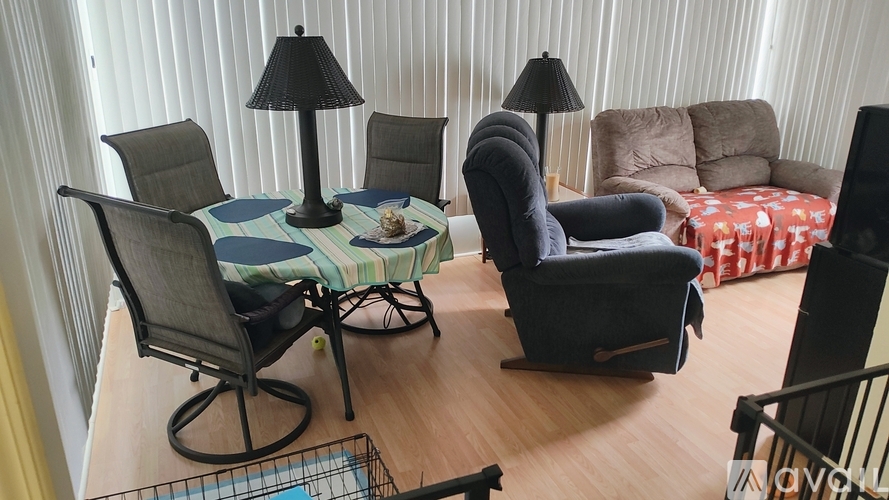 A living room with a grey chair, a black table and a sofa.