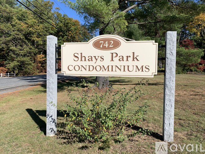 A sign for Shays Park Condominiums stands in a grassy area.