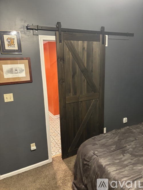 A bedroom with a bed, a sliding door, and pictures on the wall.