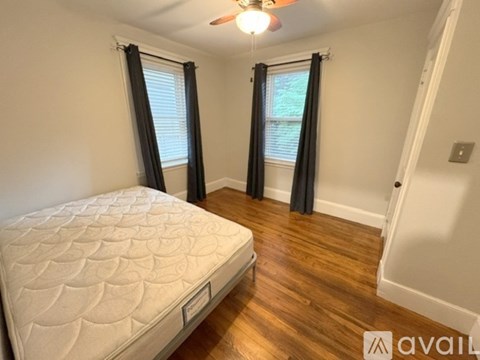 A bedroom with a large bed and a ceiling fan.