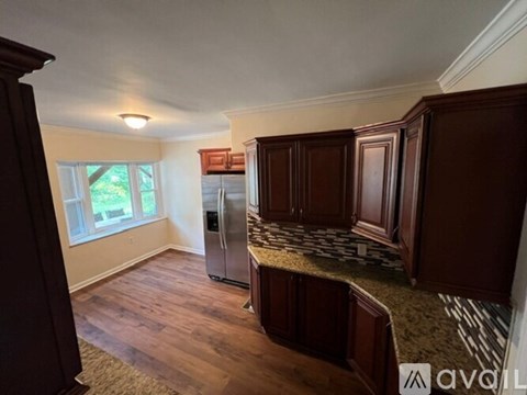 A kitchen with wooden cabinets and a refrigerator.