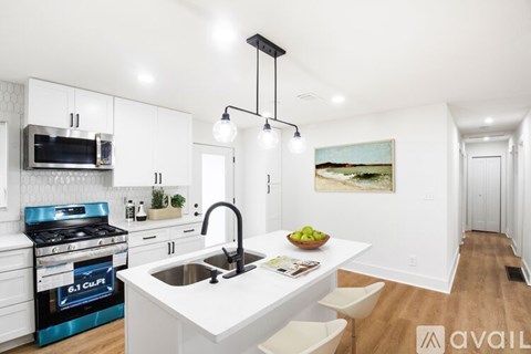 A modern kitchen with white cabinets and a black stove top.