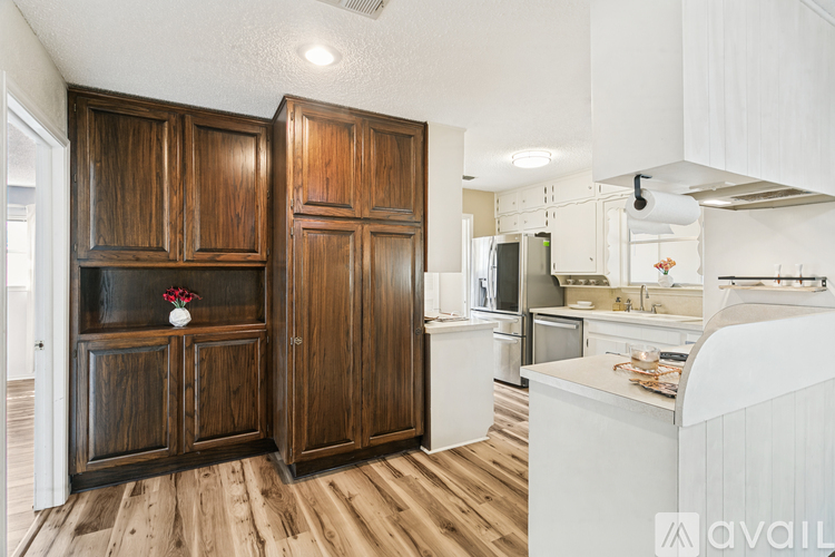 A kitchen with wooden cabinets and a white counter.