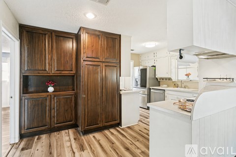 A kitchen with wooden cabinets and a white counter.