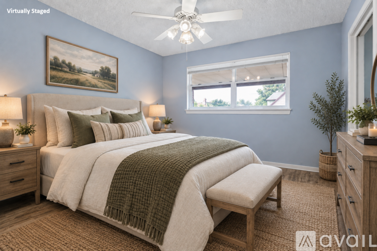 A bedroom with a large bed and a ceiling fan.