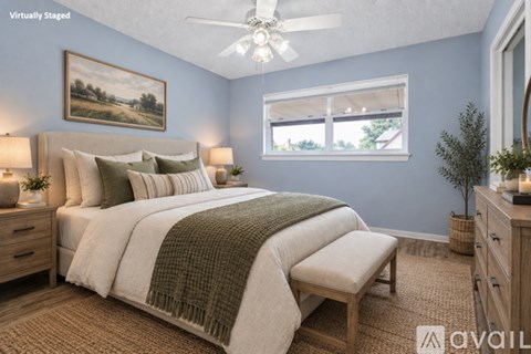 A bedroom with a large bed and a ceiling fan.