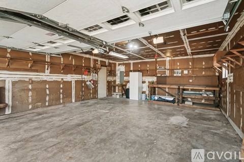 A large empty warehouse space with wooden walls and concrete floor.