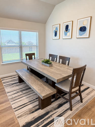 A dining room with a wooden table and chairs.