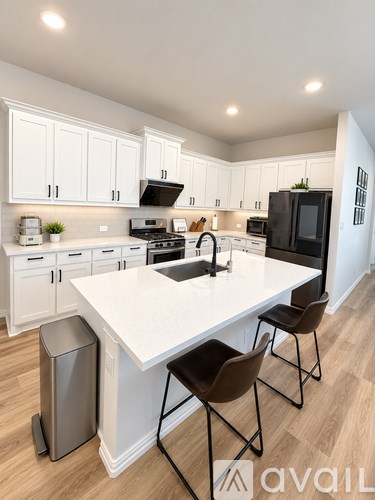 A modern kitchen with white cabinets and a large island.