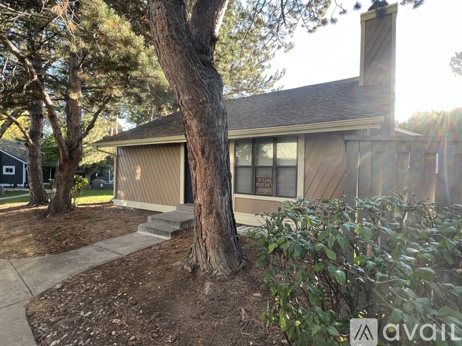 A house with a tree in front of it is for sale.