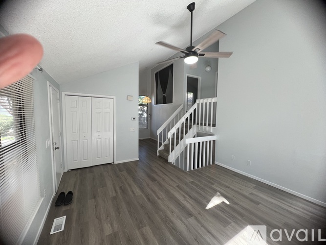 A room with a staircase and a ceiling fan.