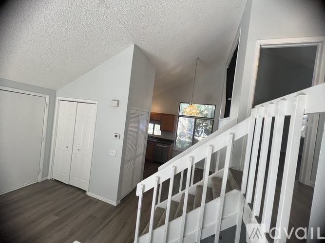A white staircase with a TV mounted on the wall.