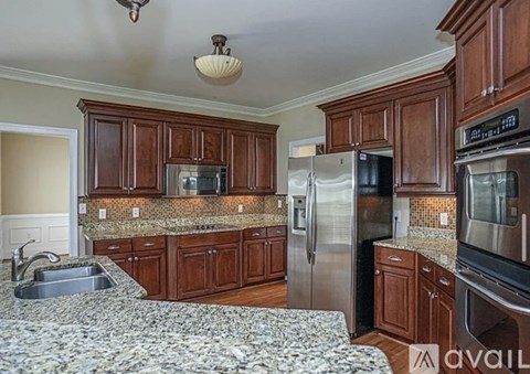 A kitchen with wooden cabinets and granite countertops.