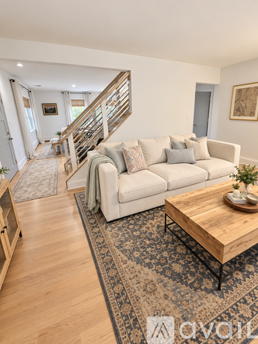 A living room with a white couch and a wooden coffee table.