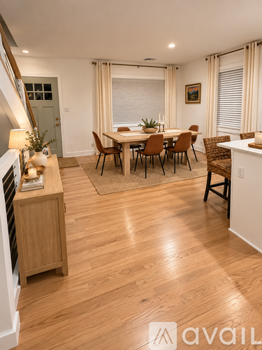 A dining room with a wooden floor and a white wall.
