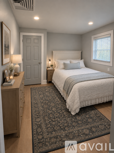 A bedroom with a large bed and a rug on the floor.