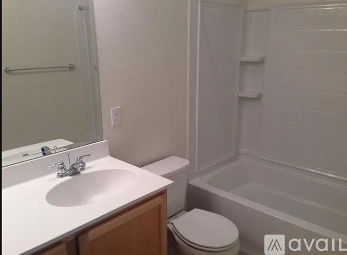 A white bathroom with a toilet, sink, and bathtub.