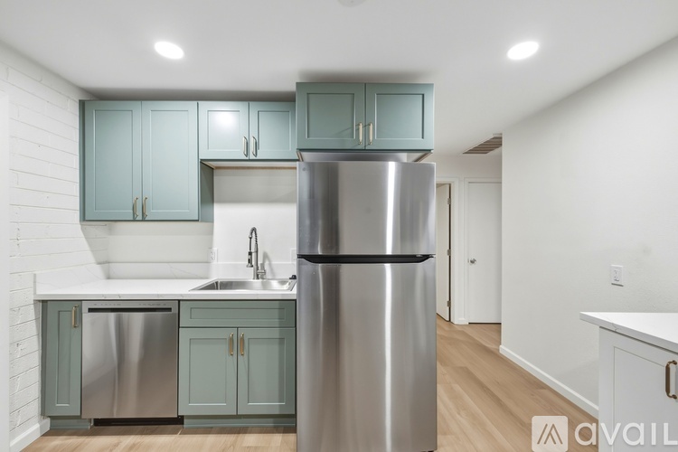 A kitchen with a stainless steel refrigerator and cabinets.