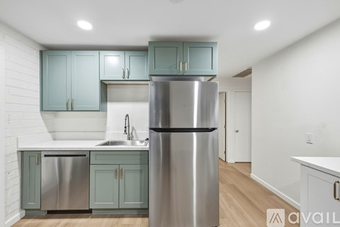 A kitchen with a stainless steel refrigerator and cabinets.