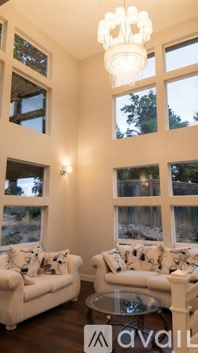 A living room with a white couch and a glass table.