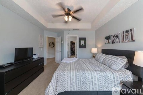A bedroom with a large bed and a ceiling fan.