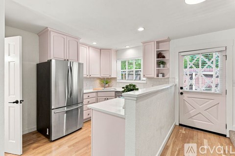 A kitchen with pink cabinets and a white island.