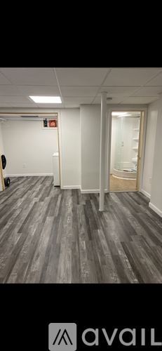 A room with wooden flooring and white walls.
