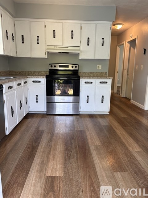 A kitchen with white cabinets and a black stove top oven.