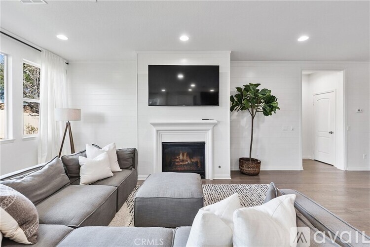 A living room with a grey couch and a fireplace.