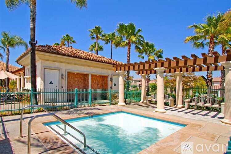 A pool area with a building and palm trees.