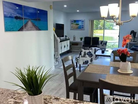 A dining room with a table set for two and a view of the ocean through the window.