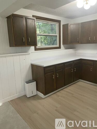 A kitchen with brown cabinets and a white countertop.