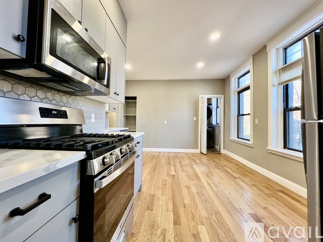 A modern kitchen with a stove top oven and microwave above it.