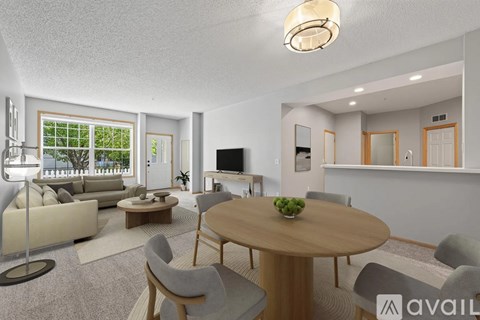 A living room with a round table and chairs, a sofa, and a television.