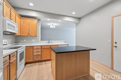 A kitchen with wooden cabinets and a black countertop.