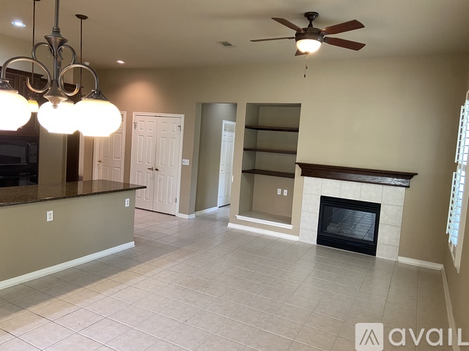 A spacious living room with a fireplace and built-in shelves.