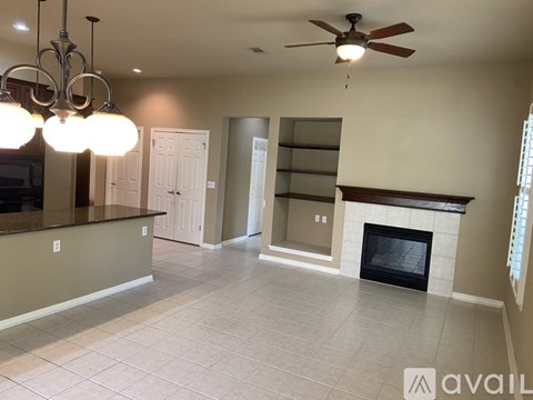 A spacious living room with a fireplace and built-in shelves.
