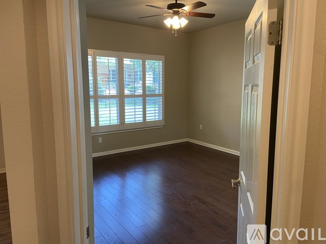 A room with a ceiling fan and a door.