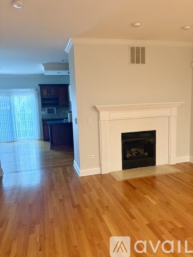 A living room with a fireplace and wooden floors.