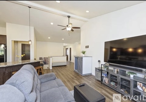 A modern living room with a grey sofa and a television.