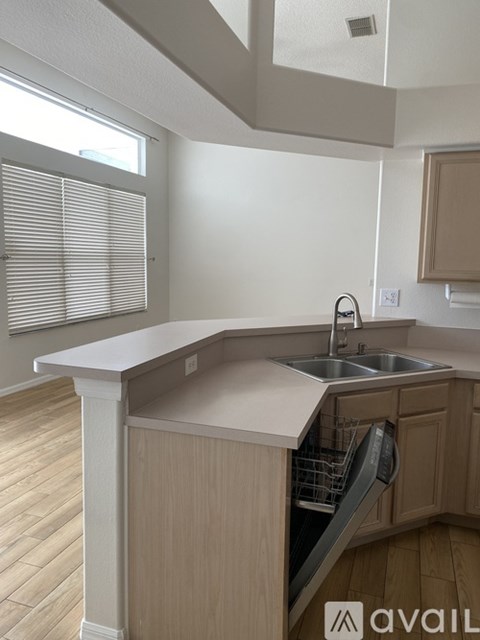 A kitchen with a sink and a window with blinds.