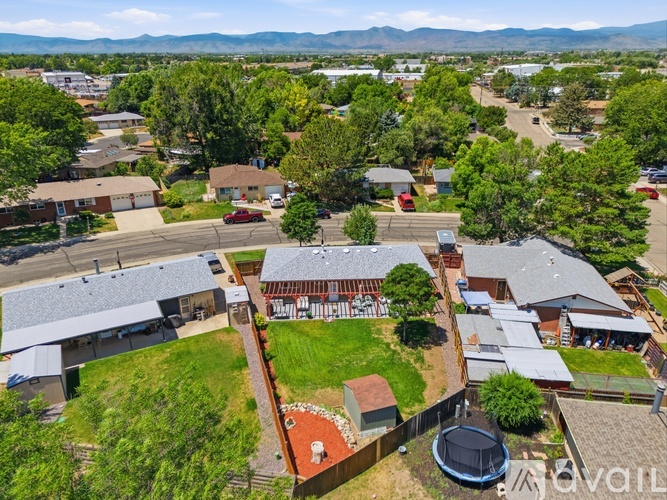 A bird's eye view of a residential area with houses, trees, and a playground.
