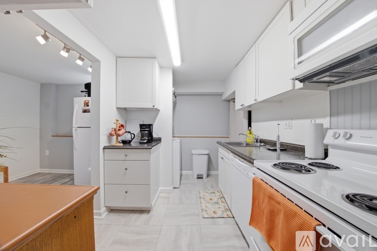A kitchen with white appliances and a wooden counter.