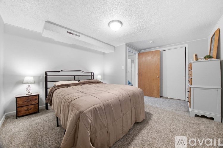 A bedroom with a bed, nightstand, and a dresser.