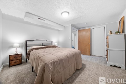 A bedroom with a bed, nightstand, and a dresser.