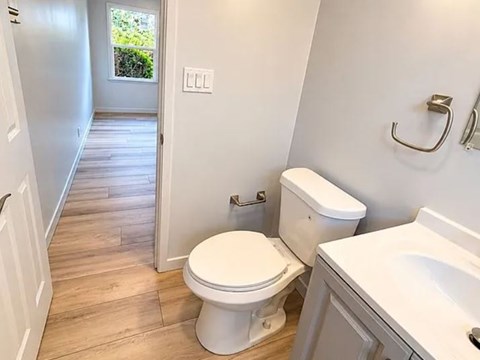 A white toilet sits in a bathroom next to a sink.