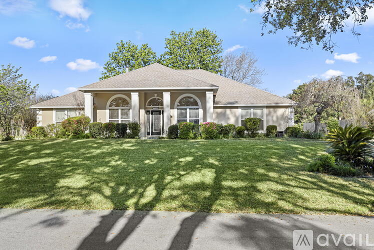 A house with a well-manicured lawn and trees in the background.