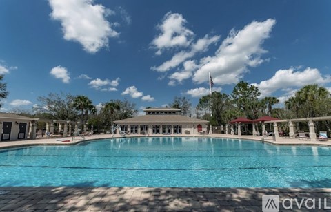 A large swimming pool with a building in the background and a flag flying.